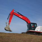 A Danfoss excavator on a dirt hill.